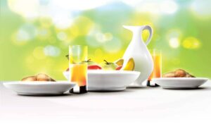 وکتور میز صبحانه با لیوان آب پرتقال و بشقاب میوه و نان